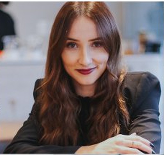 Daiane Aguilar, psicóloga, sorrindo em seu consultório